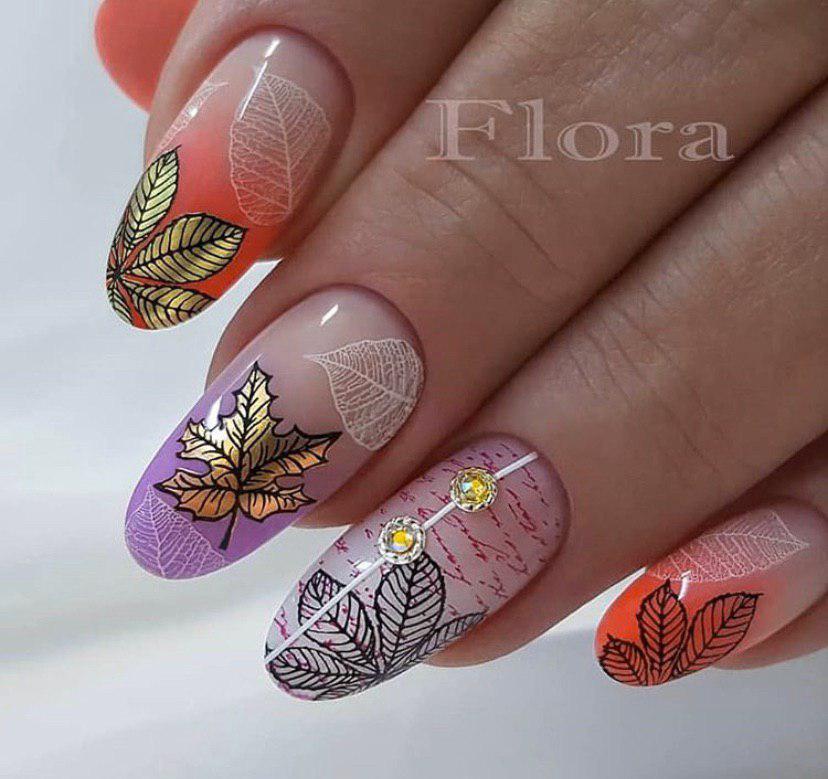 Маникюр с дизайном омбре с бежевой основой и листьями на осень на овальной форме ногтей