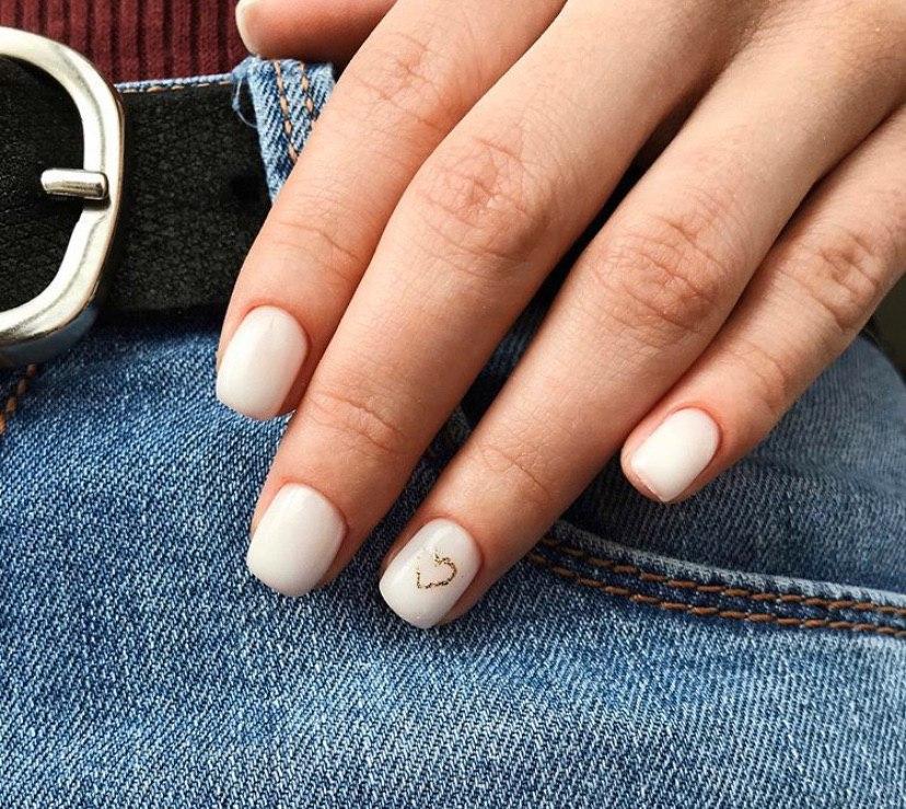 Молочный маникюр с нежным сердечком из золота на коротких ногтях