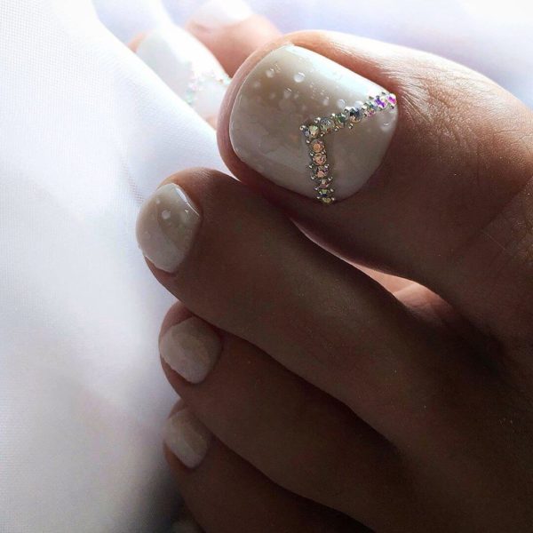Белый педикюр со стразами у лунки